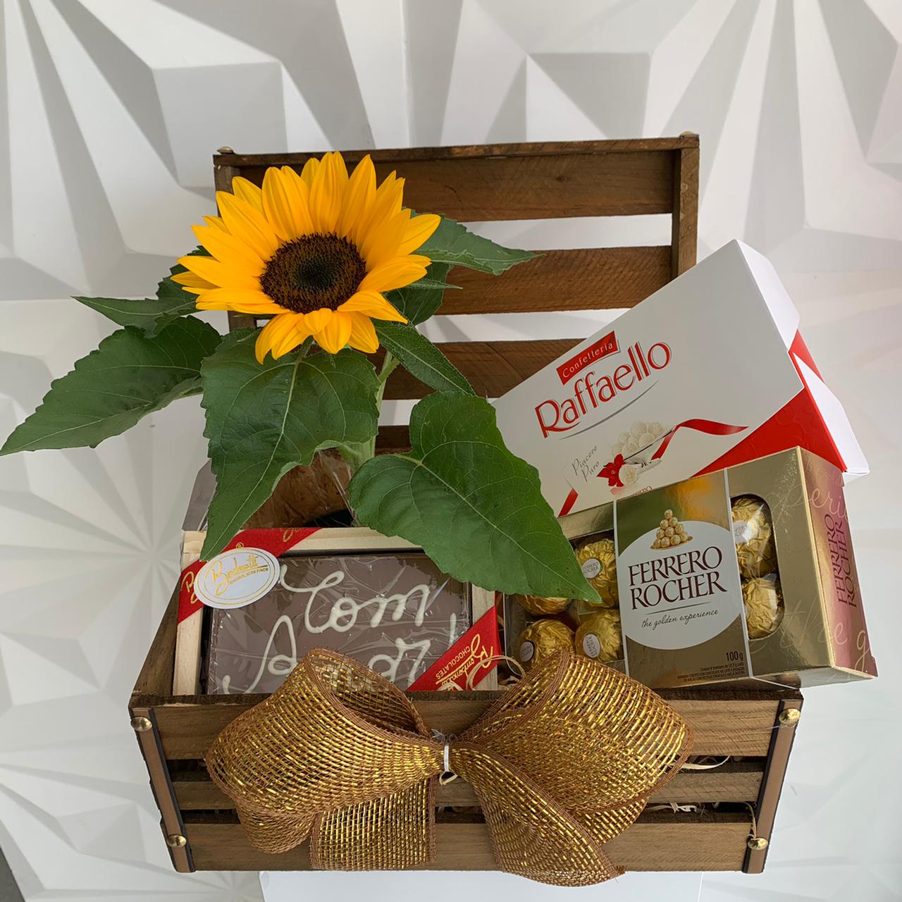 Baú com arranjo de girassol e chocolates