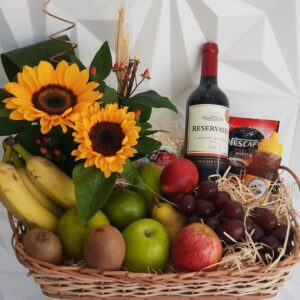 Cesta de frutas e vinho com arranjo